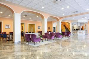 a large room with purple chairs and a table in it at Hotel Columbia Terme in Abano Terme