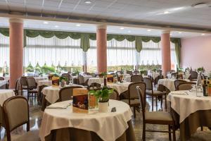 une salle à manger avec des tables et des chaises blanches dans l'établissement Hotel Columbia Terme, à Abano Terme