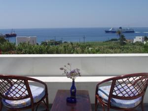 a table and two chairs with a view of the ocean at Parathyro Sto Aigaio 1 in Tinos