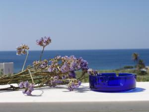 un cuenco azul sentado en una mesa con flores púrpuras en Parathyro Sto Aigaio 1, en Tinos