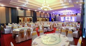 廊開的住宿－阿薩灣酒店，一个带白色桌椅的大型宴会厅