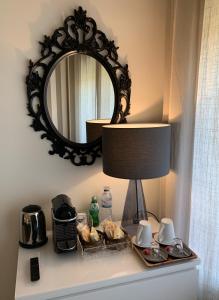 uno specchio sopra una tavola con lampada e cibo di Near the Airport a Moreira