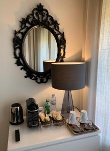 a mirror above a table with a lamp and food at Near the Airport in Moreira