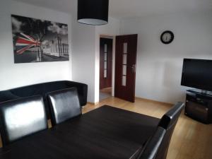 salon ze stołem i telewizorem w obiekcie Apartament Centrum w Szczecinku +5 zdjęć