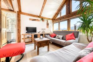 uma sala de estar com um sofá e uma televisão em Chalet Fischer by A-Appartments em Bürserberg