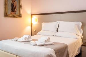 una camera d'albergo con due asciugamani su un letto di Hotel Rosa a Baveno