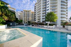 una piscina frente a un gran edificio de apartamentos en Trilogy Surfers Paradise, en Gold Coast