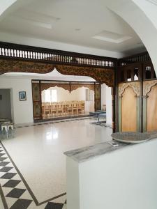Habitación grande con mesa y sillas. en Dar Mamina en Sīdī ash Shammākh