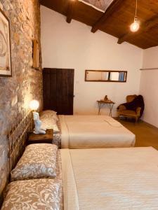 a bedroom with two beds and a stone wall at CaStella B&B in Monte Colombo