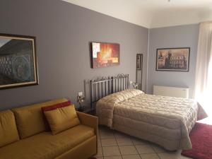 1 dormitorio con 1 cama y 1 sofá en Affittacamere La Piazzetta, en Caltagirone