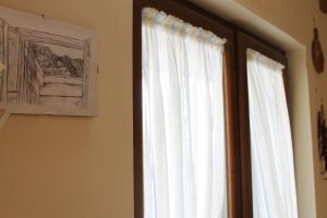 okno z białymi zasłonami w pokoju w obiekcie Casa Marinella w mieście Agerola
