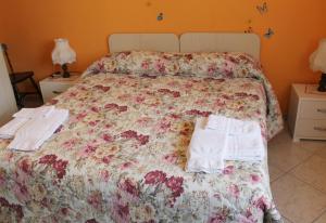 a bed with a floral bedspread and towels on it at Casa Marinella in Agerola