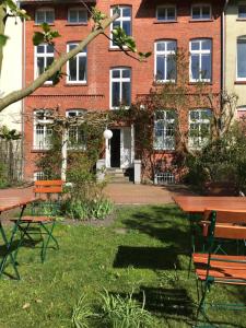 a building with a picnic table and chairs in the grass at Villa Friedenstraße 11 in Lüneburg