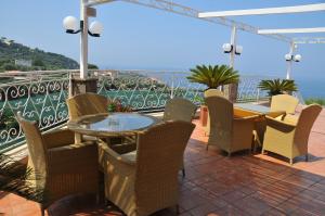 a patio with a table and chairs and the ocean at Hotel Dania in Sorrento