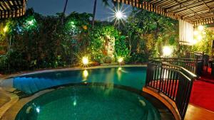 una piscina en un patio trasero por la noche con luces en Amaroossa Cosmo Jakarta, en Yakarta