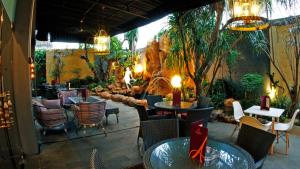 a restaurant with tables and chairs in a garden at Amaroossa Cosmo Jakarta in Jakarta