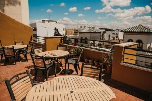 a patio with tables and chairs on a balcony at Hotel Nuro in Barbate