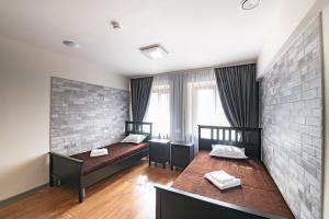 a bedroom with two beds and a brick wall at 1915 Hostel in Vladivostok