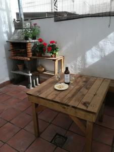 a wooden table with a bottle of wine and two glasses at Apto con patio y barbacoa BBQ H de la Reina in Córdoba