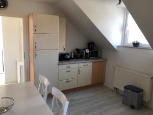 a kitchen with a table and a kitchen under an attic at eifelTIME - Ferienwohnung in Bad Münstereifel
