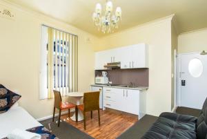 a kitchen and a living room with a table and chairs at The North Shore Hotel in Sydney