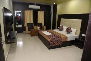 a bedroom with a bed and a tv in it at Hotel Mayank in Rewa