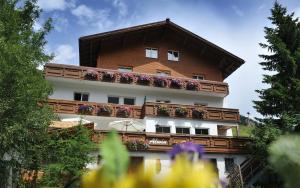 un edificio con un balcón con flores. en Pension Alwin, en Lech am Arlberg