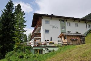 a large white building on a hill at Pension Alwin in Lech am Arlberg