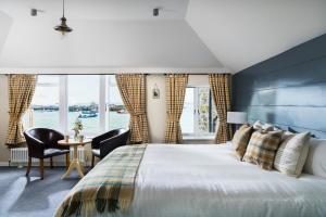 a bedroom with a large bed and a table and chairs at Lifeboat Inn in St Ives