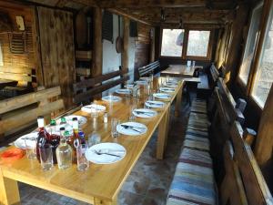 a long wooden table with plates and drinks on it at Etno kuce Miljevic in Šipovo