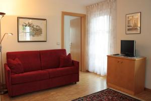 a living room with a red couch and a television at Appartement Prieth in Resia