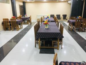 a dining room with tables and chairs with flowers on it at Hotel Mayank in Rewa