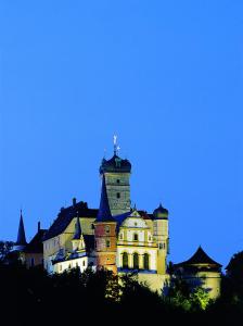 Un castillo con una torre de reloj encima. en Hotel-Gasthof Krone-Lax en Scheinfeld