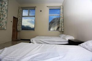 - 2 lits dans une chambre avec 2 fenêtres dans l'établissement Junction Resort, à Jaglot
