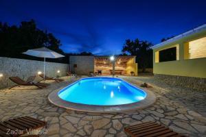 - une piscine dans une cour la nuit dans l'établissement Peace and relaxation Villa Didov dvor, à Vinjerac