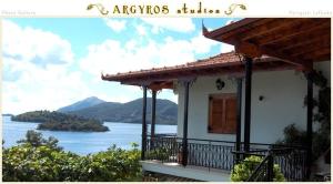 a house with a balcony with a view of a lake at Argyros Studios in Nydri