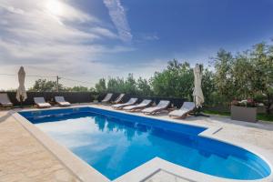 - une piscine avec des chaises longues dans l'établissement Villa Balen, à Lisičići