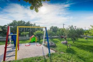 un parc avec une aire de jeux sur gazon dans l'établissement Villa Balen, à Lisičići