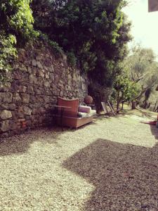 un sofá sentado junto a una pared de piedra en Hotel Villa Belvedere, en Bonassola