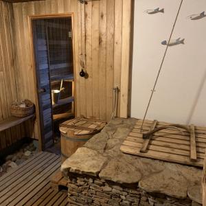 a room with a stone fireplace and a wooden door at Muha Beach Holiday Home in Riksu