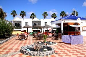 a patio with tables and chairs and a building at Casa Anna in Caleta De Fuste