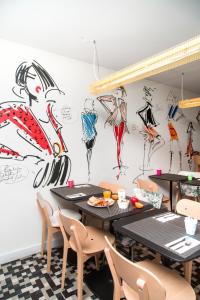 a room filled with tables, chairs, and a painting on the wall at Ibis Styles Paris Gare Saint Lazare in Paris