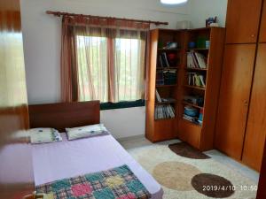 a bedroom with a bed and a book shelf at Villa Sea Esta in Maronia