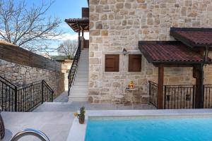 a house with a swimming pool next to a building at Villa Laurana ZadarVillas in Pakoštane