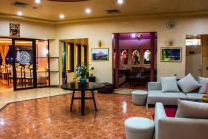 a living room with a table and a couch and chairs at Hotel Ouzoud Beni Mellal in Beni Mellal