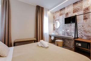 a hotel room with a bed and a tv at Hotel Villa Katy in Bardolino