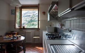 a kitchen with a stove and a table and a window at Le Terrazze di katia apartment in Riomaggiore