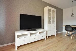 Televízia a/alebo spoločenská miestnosť v ubytovaní Apart-Invest Apartament Pastelowy