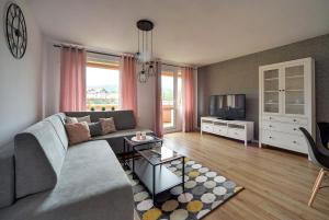 Televízia a/alebo spoločenská miestnosť v ubytovaní Apart-Invest Apartament Pastelowy