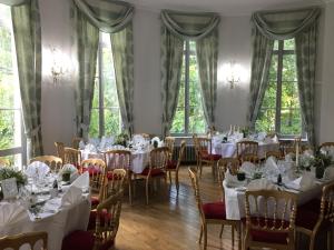 a room full of tables and chairs with white table settings at Chateau D'aubry in Aubry